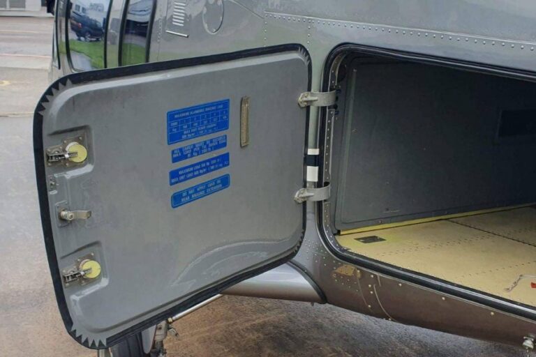 Open luggage hold door of an Agusta 109 Grand helicopter showing the baggage space