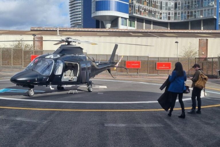 Passengers walking to board a helicopter on the helipad at London Heliport, Battersea