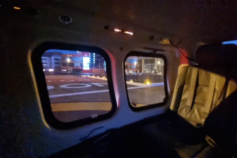 The landing pad at London Heliport seen at night through the cabin windows of a helicopter